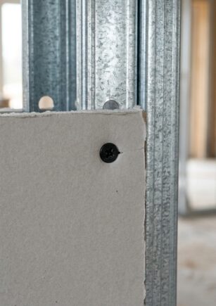 Tornillos para metalcon y volcanita instalados al ras en placa de yeso-cartón sobre perfil galvanizado.